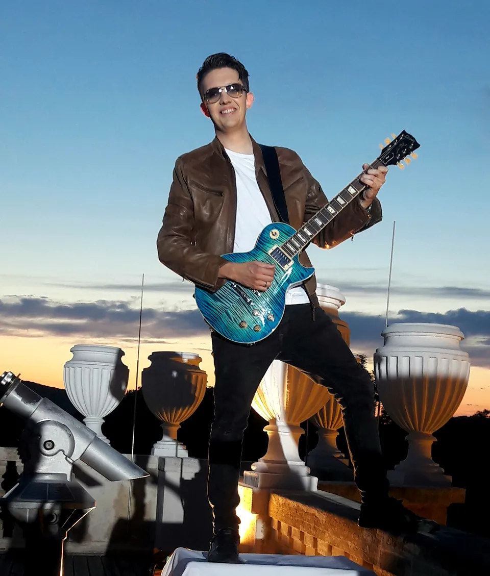 Gitarrist auf einer Dachterrasse bei Sonnenuntergang